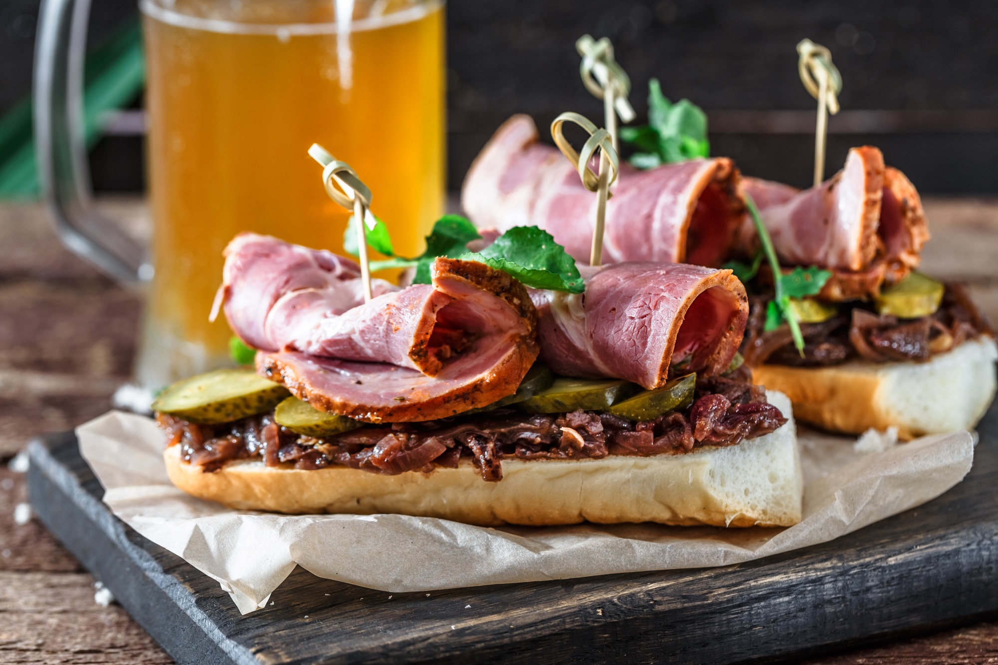 Sandwiches with smoked meat, onion jam and mug of beer